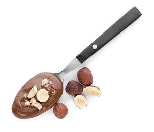 Spoon with delicious chocolate paste and hazelnuts on white background, top view