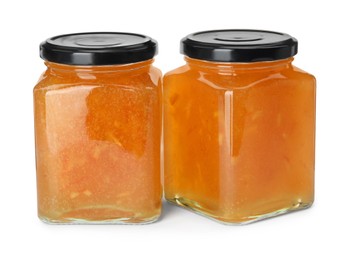 Photo of Delicious orange marmalade in jars on white background