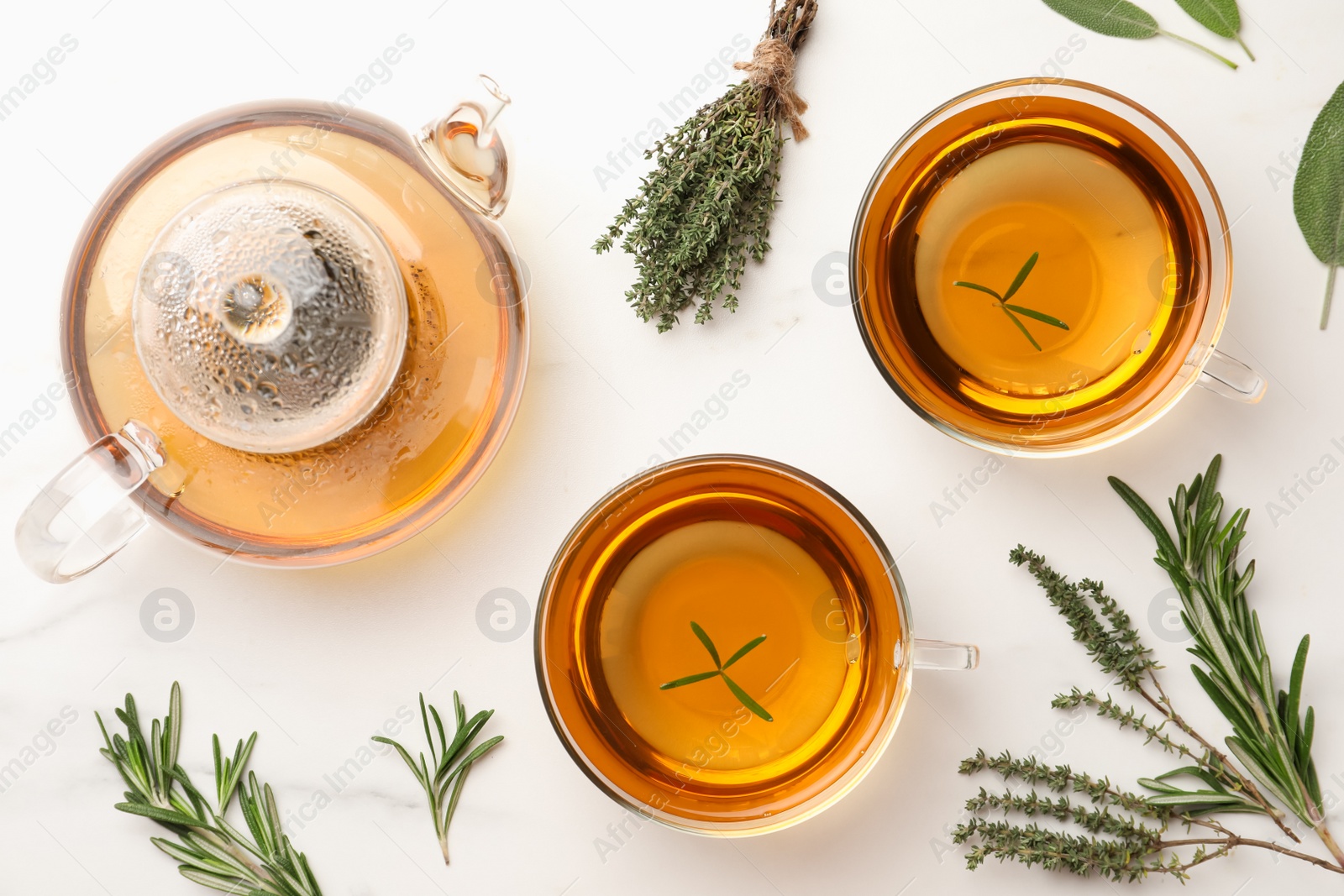 Photo of Aromatic herbal tea with thyme, rosemary and sage on white marble table, flat lay