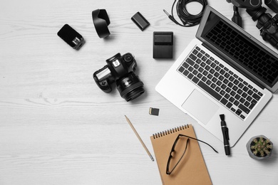 Flat lay composition with equipment for professional photographer on wooden background. Space for text