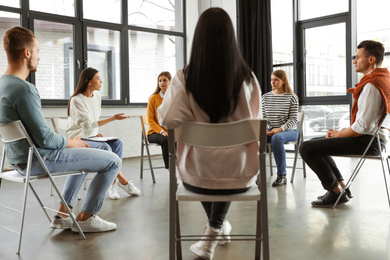 Psychotherapist working with patients in group therapy session indoors