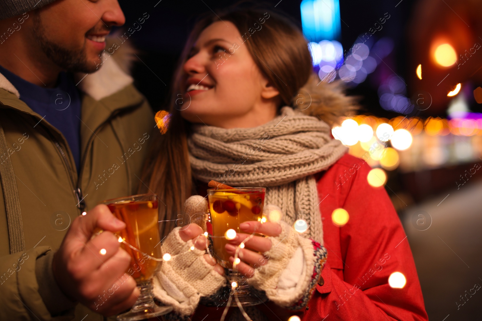 Photo of Happy couple with mulled wine at winter fair