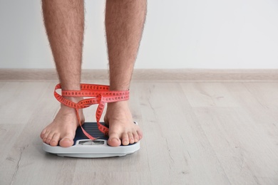 Photo of Overweight man measuring his weight indoors