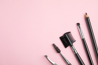 Photo of Set of professional eyebrow tools on pink background, flat lay. Space for text