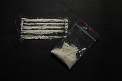 Photo of Drug addiction. Plastic bag with cocaine on dark textured background,, flat lay