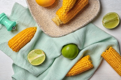 Photo of Flat lay composition with corn cobs and citrus fruits on white wooden background