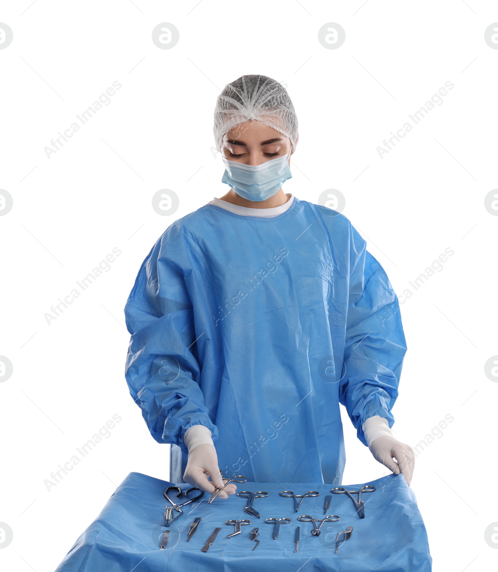 Photo of Doctor holding Mayo scissors near table with different surgical instruments on light background