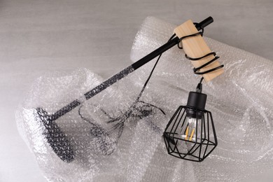 Photo of Beautiful lamp with bubble wrap light grey table