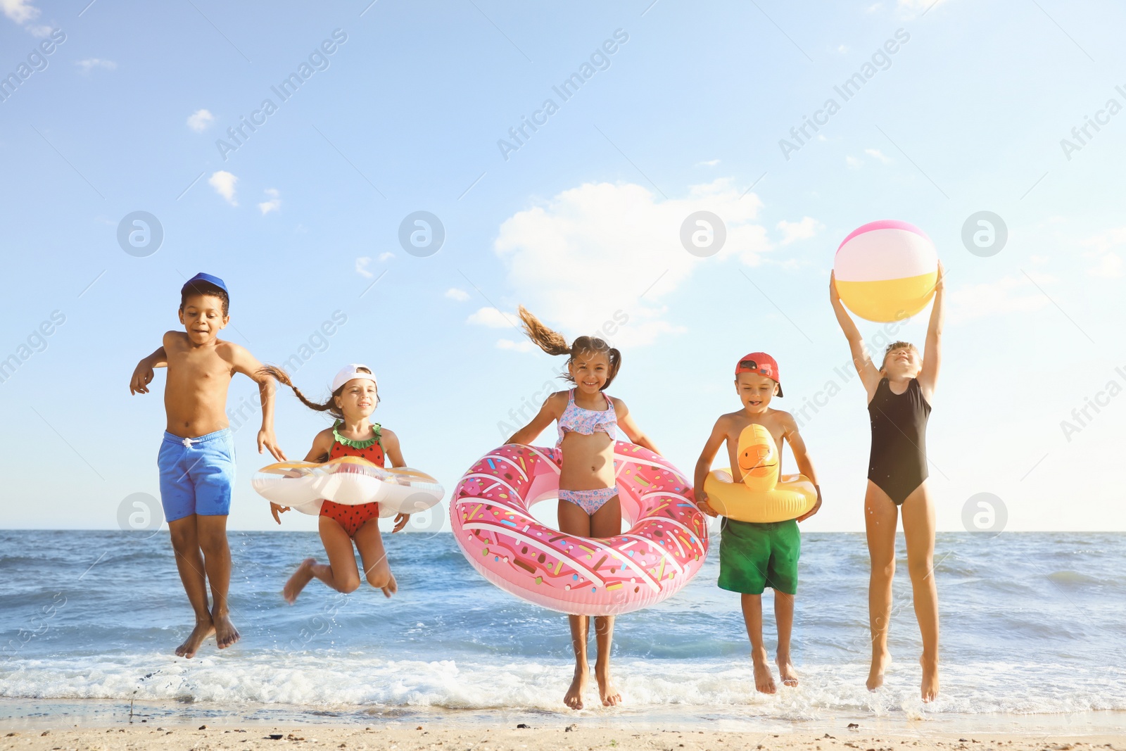 Photo of Cute children enjoying sunny day at beach. Summer camp