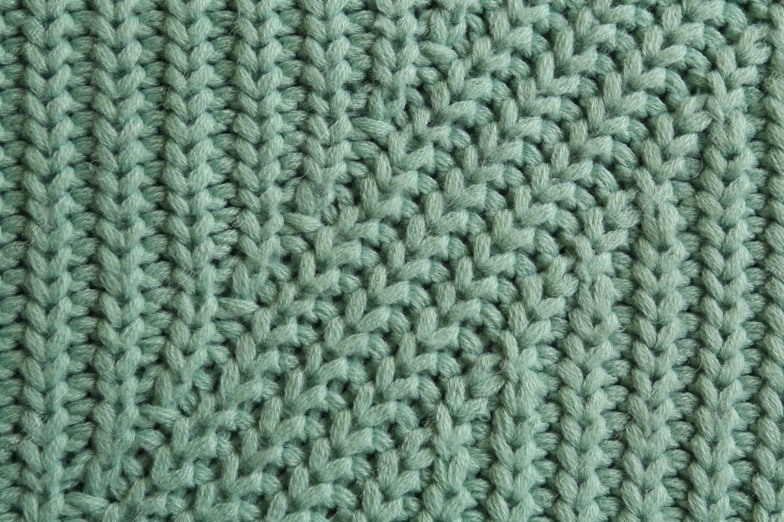 Photo of Beautiful pale green knitted fabric as background, top view