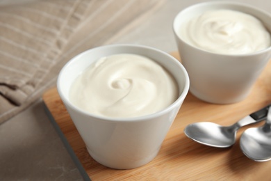 Photo of Bowls with creamy yogurt served on table
