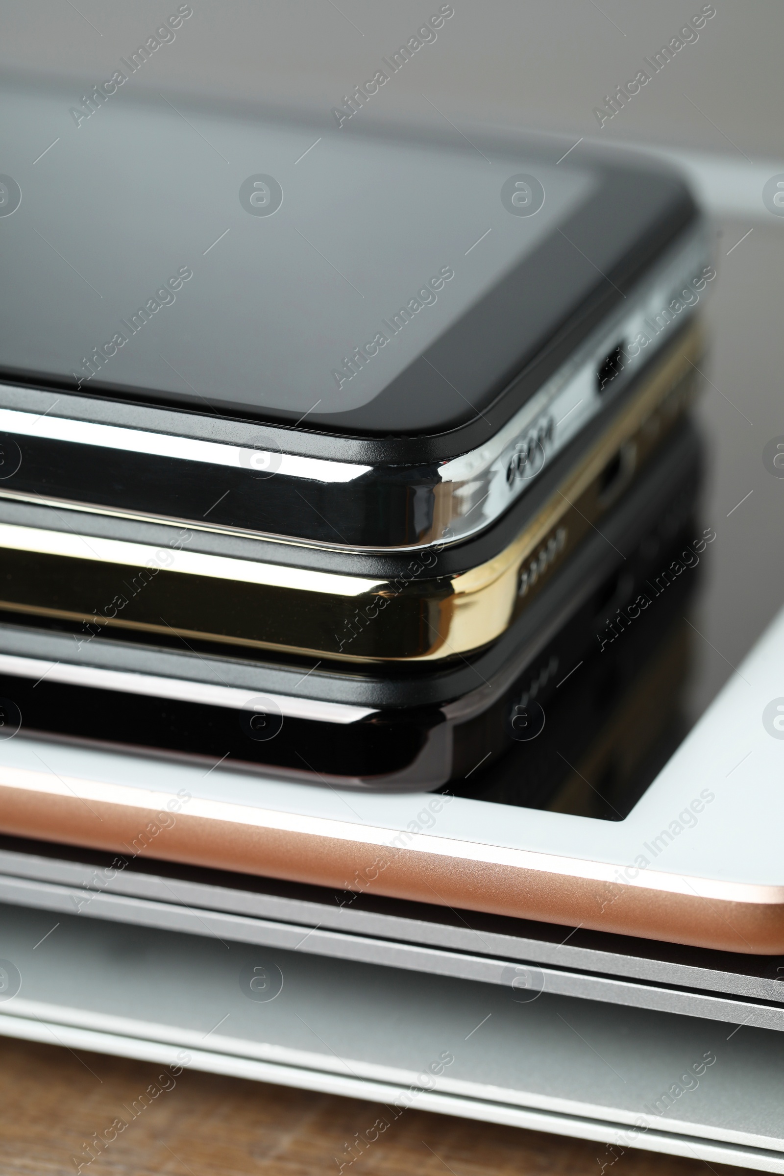 Photo of Stack of electronic devices on wooden table, closeup