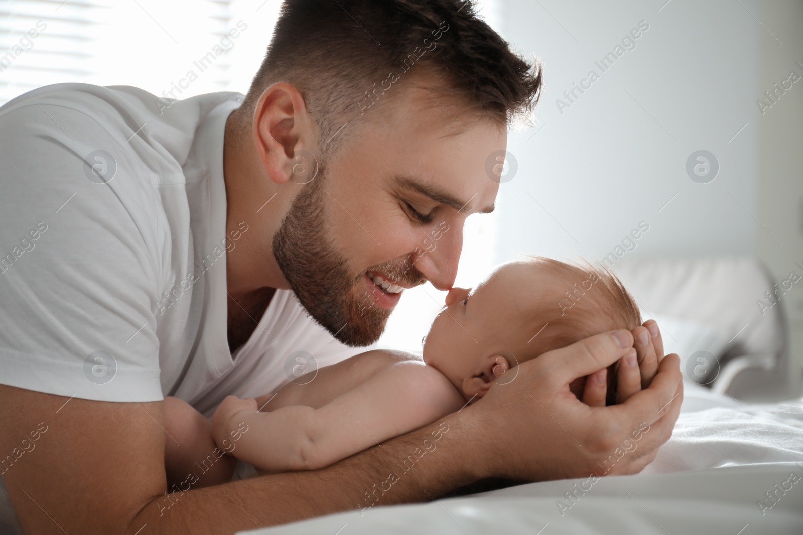 Photo of Father with his newborn son at home