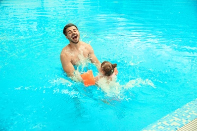 Father and daughter playing in swimming pool