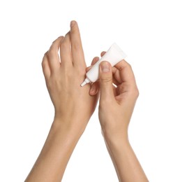 Photo of Woman applying cream from tube on hand against white background, closeup