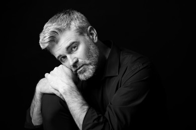 Portrait of handsome man on dark background. Black and white effect