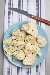 Plate with cut fresh raw cauliflower on table, top view