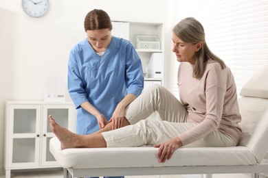 Photo of Arthritis symptoms. Doctor examining patient's leg in hospital