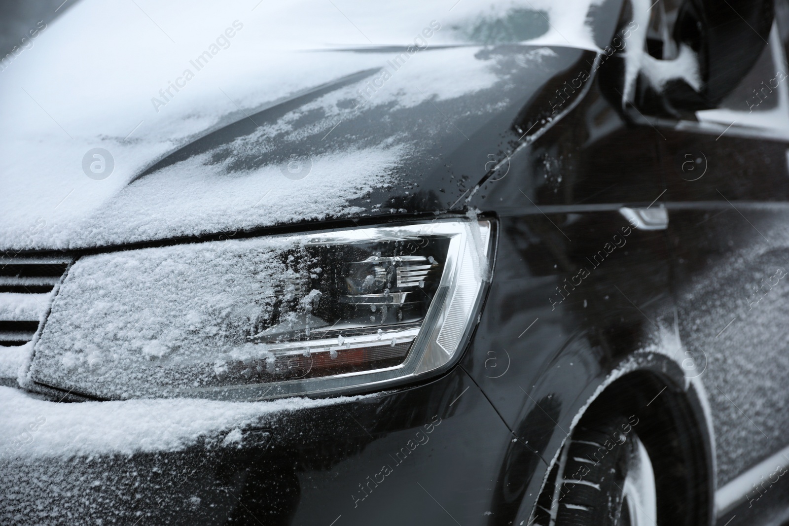 Photo of Modern car covered in snow outdoors on winter day, closeup