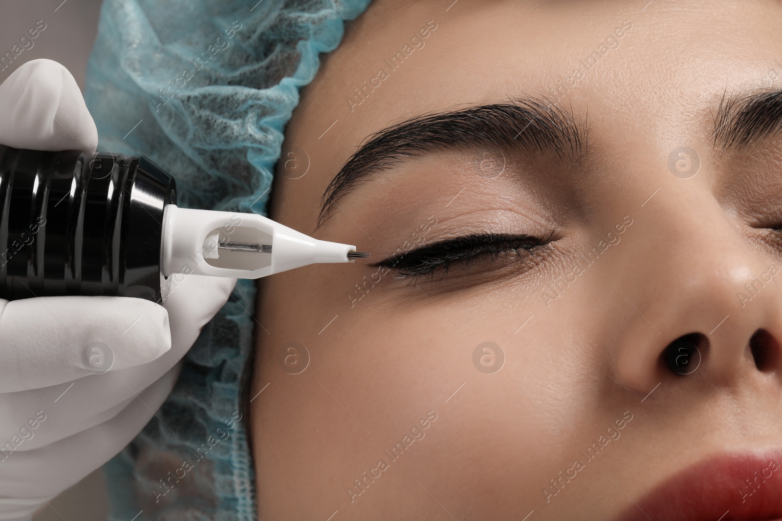 Photo of Young woman undergoing procedure of permanent eyeliner makeup, closeup