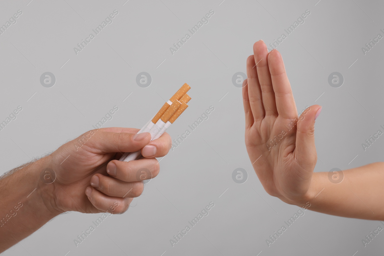 Photo of Stop smoking concept. Woman refusing cigarettes on grey background, closeup