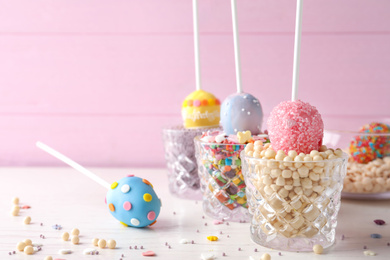 Photo of Egg shaped cake pops for Easter celebration on white wooden table