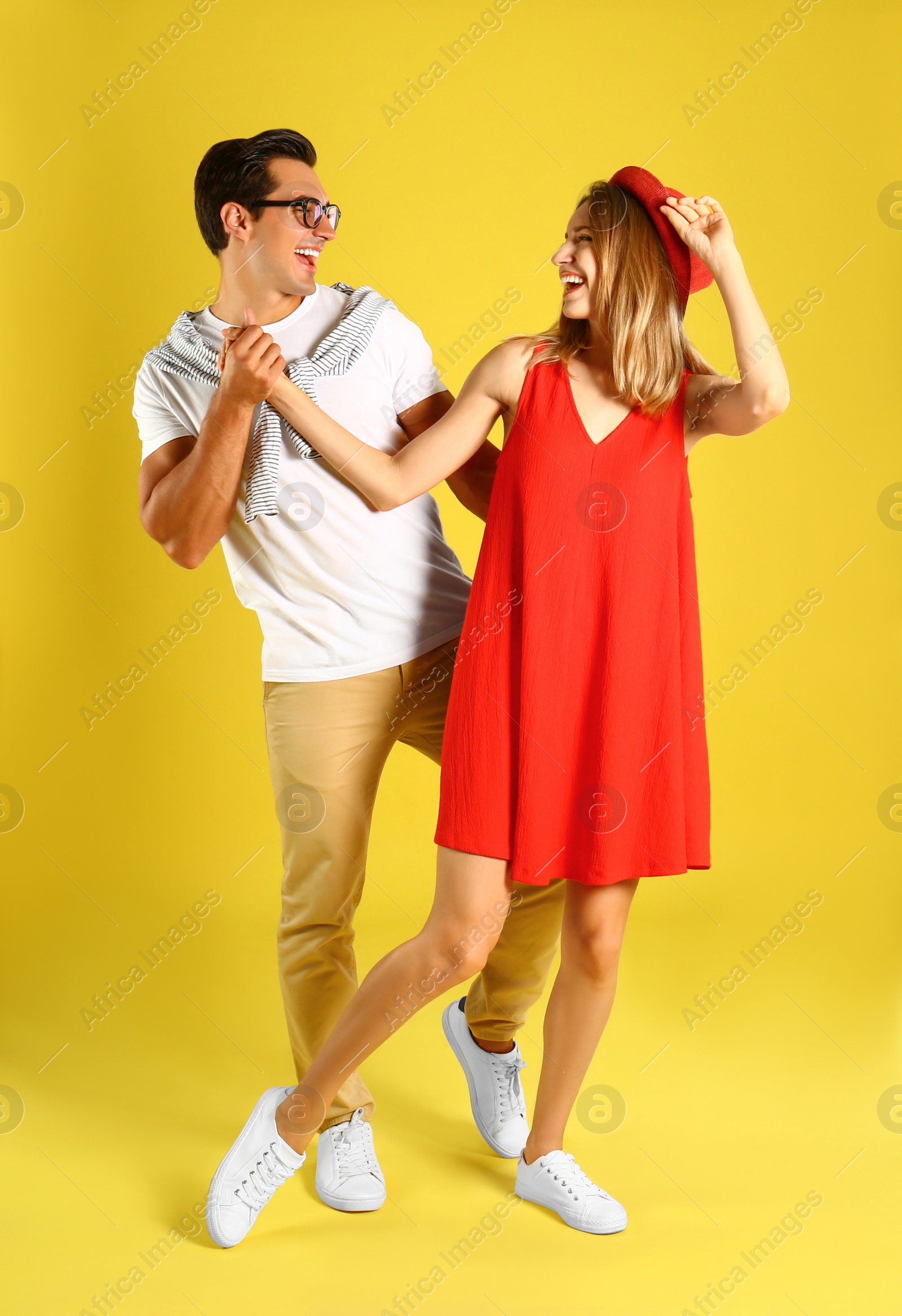 Photo of Beautiful young couple dancing on yellow background