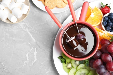 Photo of Flat lay composition with chocolate fondue and space for text on grey marble background