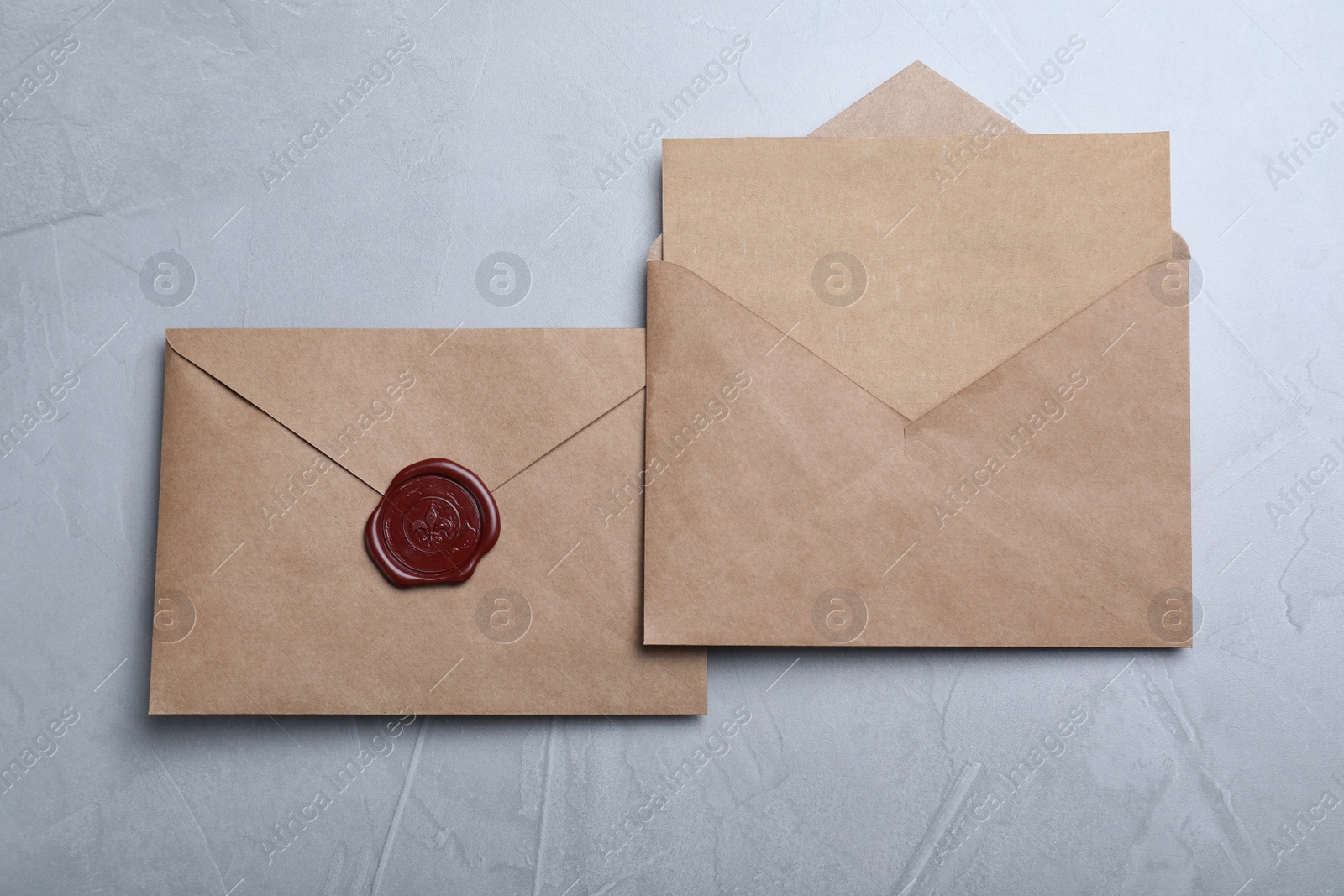 Photo of Envelopes with wax seal on grey background, flat lay