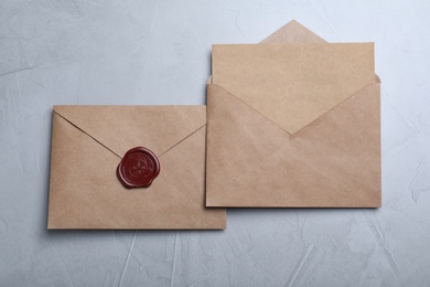 Photo of Envelopes with wax seal on grey background, flat lay
