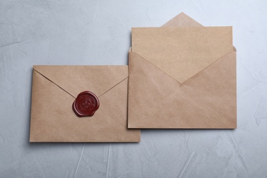 Envelopes with wax seal on grey background, flat lay