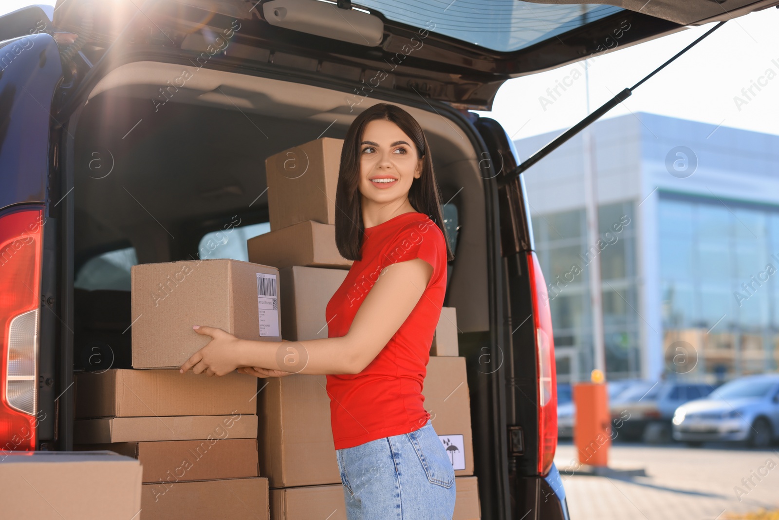 Photo of Courier taking parcel from delivery van outdoors