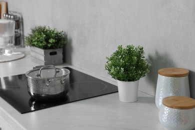 Potted artificial plants on white countertop in kitchen