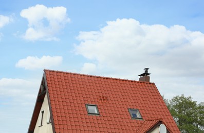 Photo of Modern house with red roof against blue sky