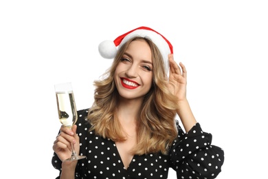 Photo of Happy young woman wearing Santa hat with glass of champagne on white background. Christmas celebration
