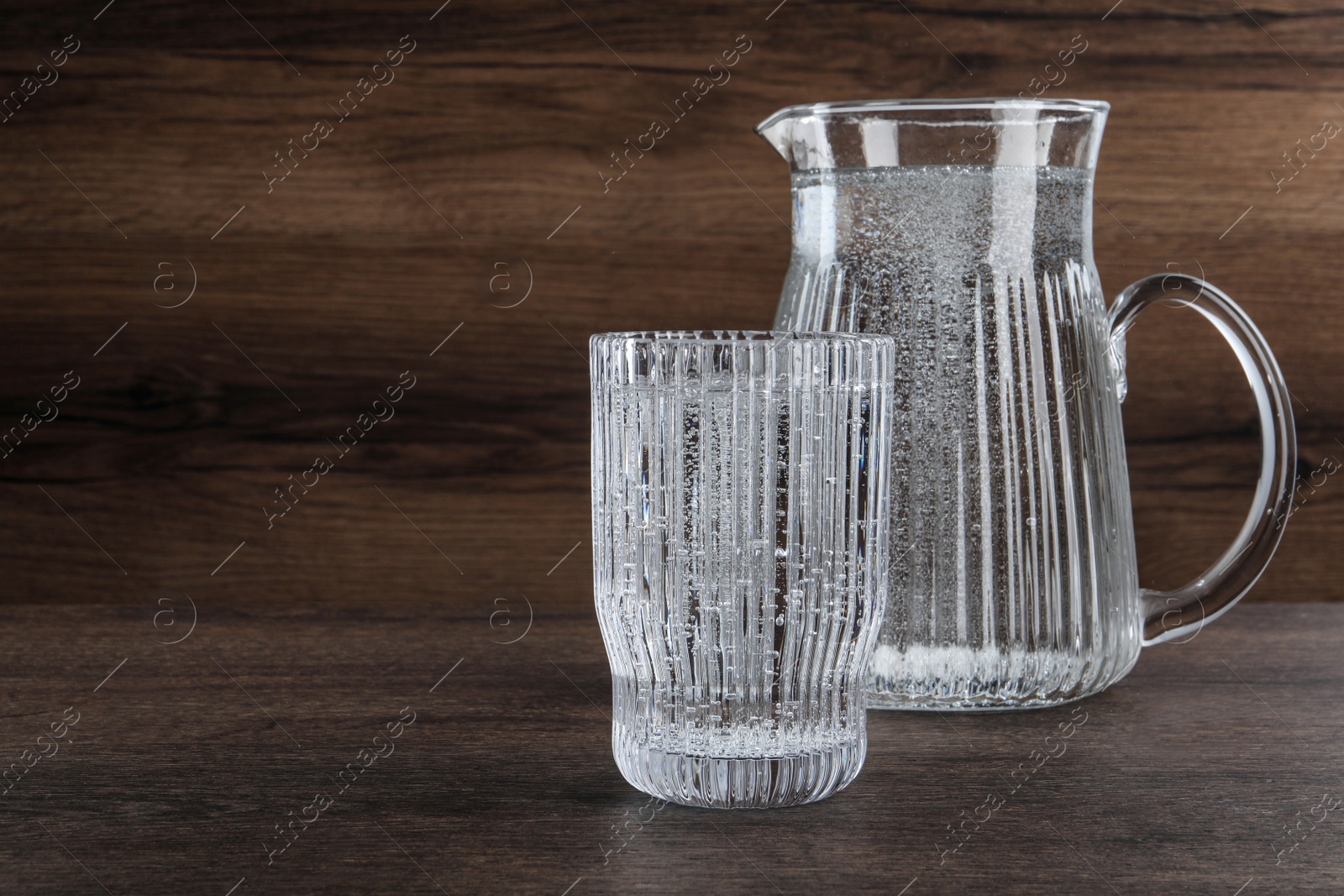 Photo of Glassware with soda water on wooden table. Space for text