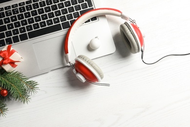 Flat lay composition with decorations, laptop and headphones on wooden background. Christmas music concept