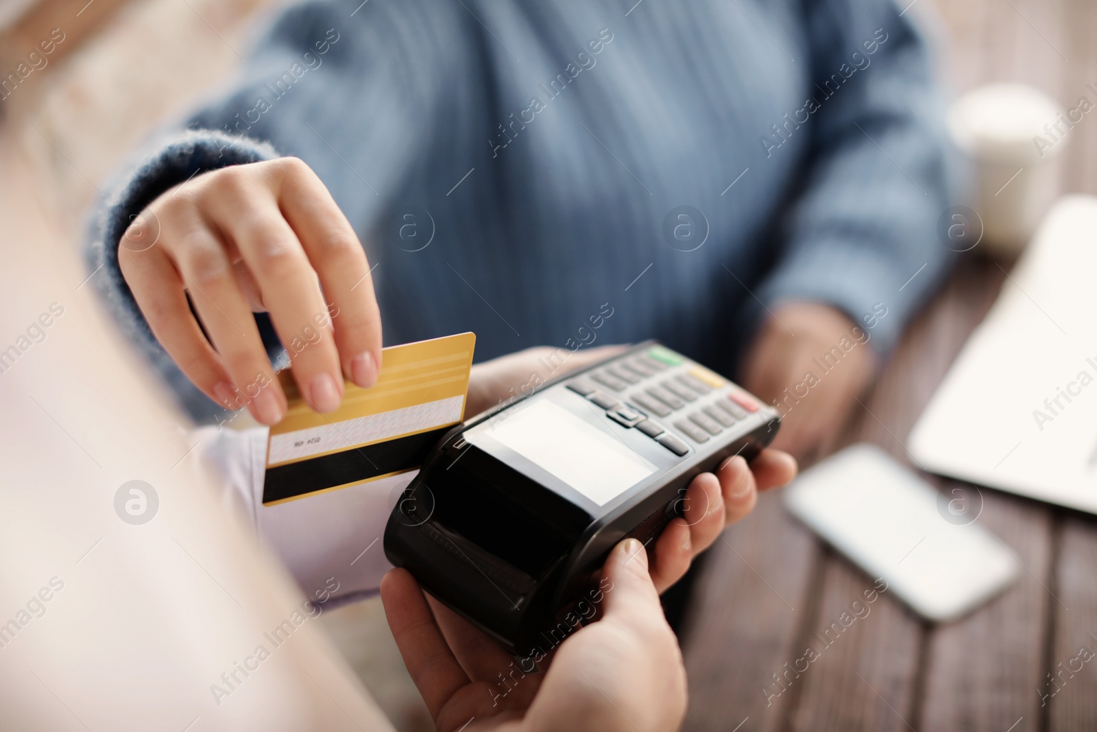 Photo of Woman with credit card using payment terminal at restaurant, closeup