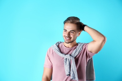 Photo of Young man with trendy hairstyle on color background