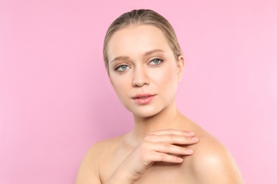 Portrait of young woman with beautiful face on pink background