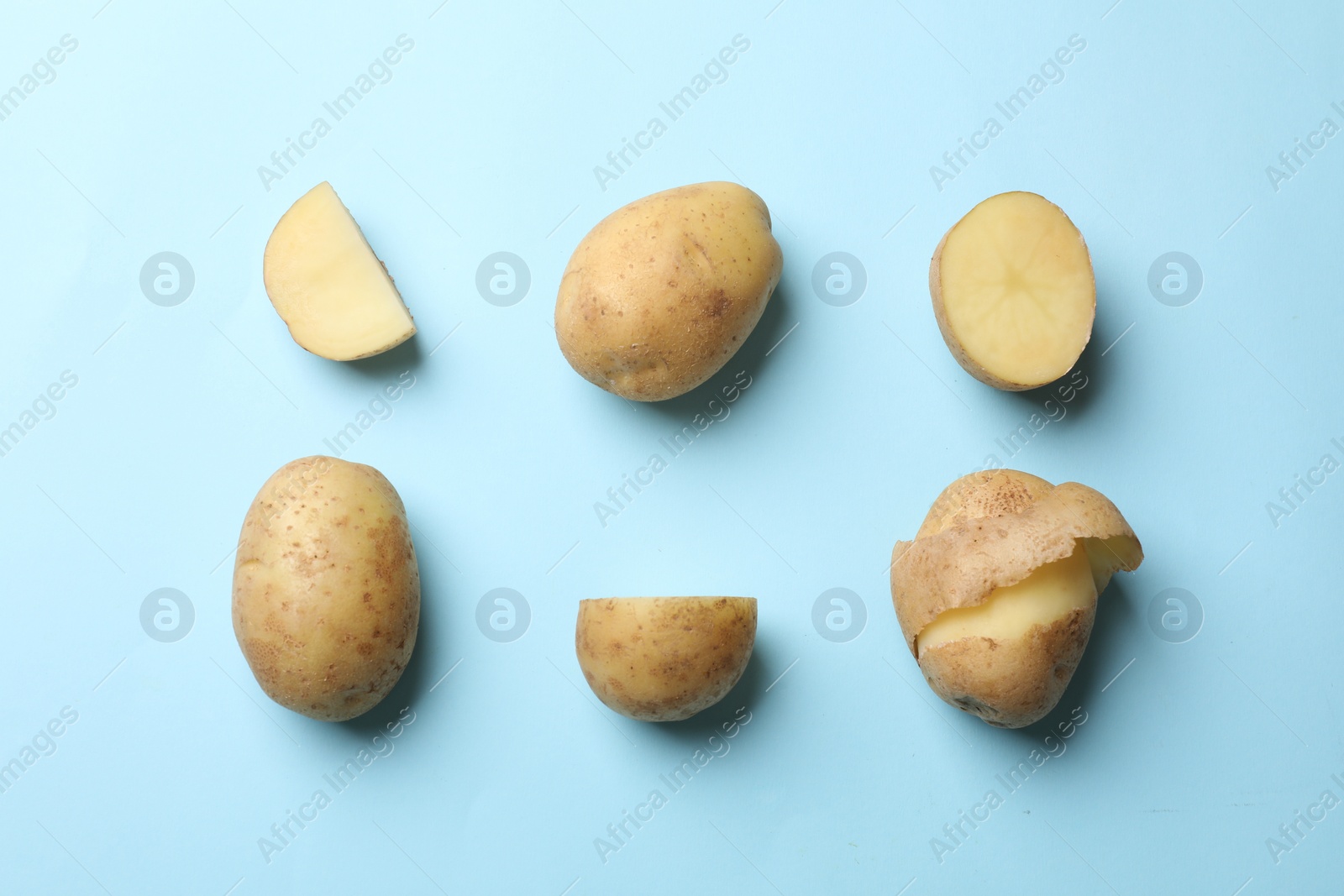 Photo of Fresh raw potatoes on light blue background, flat lay