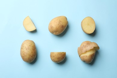 Photo of Fresh raw potatoes on light blue background, flat lay