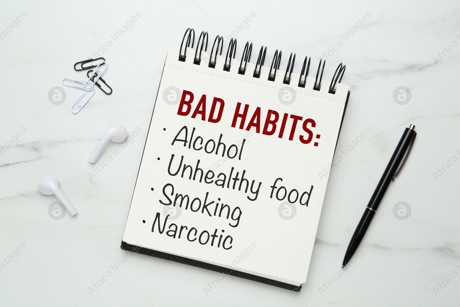 Image of Notebook with list of bad habits and pen on white marble table, flat lay. Change your lifestyle