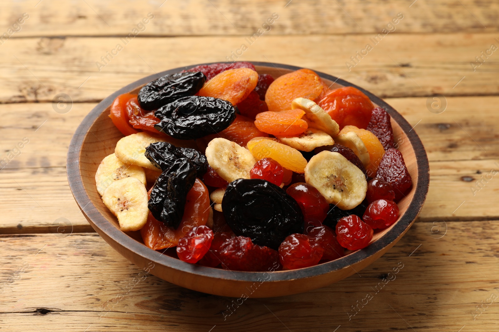 Photo of Mix of delicious dried fruits on wooden table