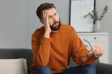 Overwhelmed man with glasses suffering at home