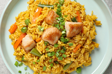 Photo of Delicious rice pilaf with chicken and vegetables in plate, closeup