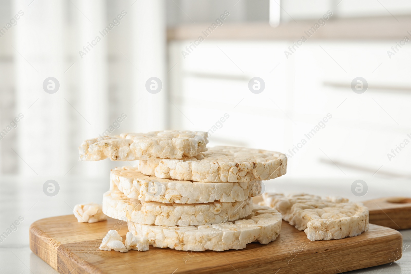 Photo of Puffed rice cakes on wooden board indoors, closeup