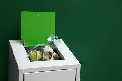 Overfilled trash bin on color background, space for text. Recycling concept