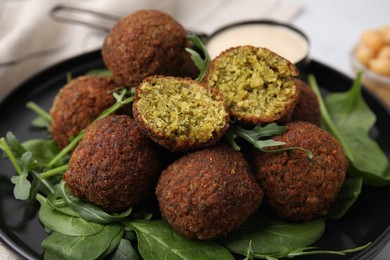 Photo of Delicious falafel balls and herbs on plate, closeup