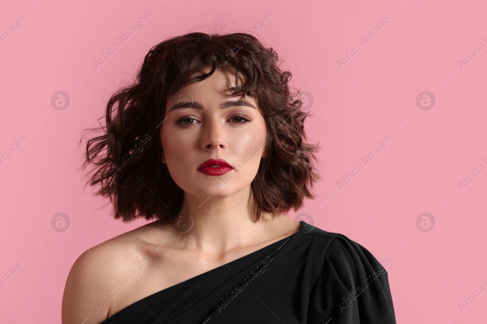 Photo of Portrait of beautiful young woman with wavy hairstyle on pink background. Space for text